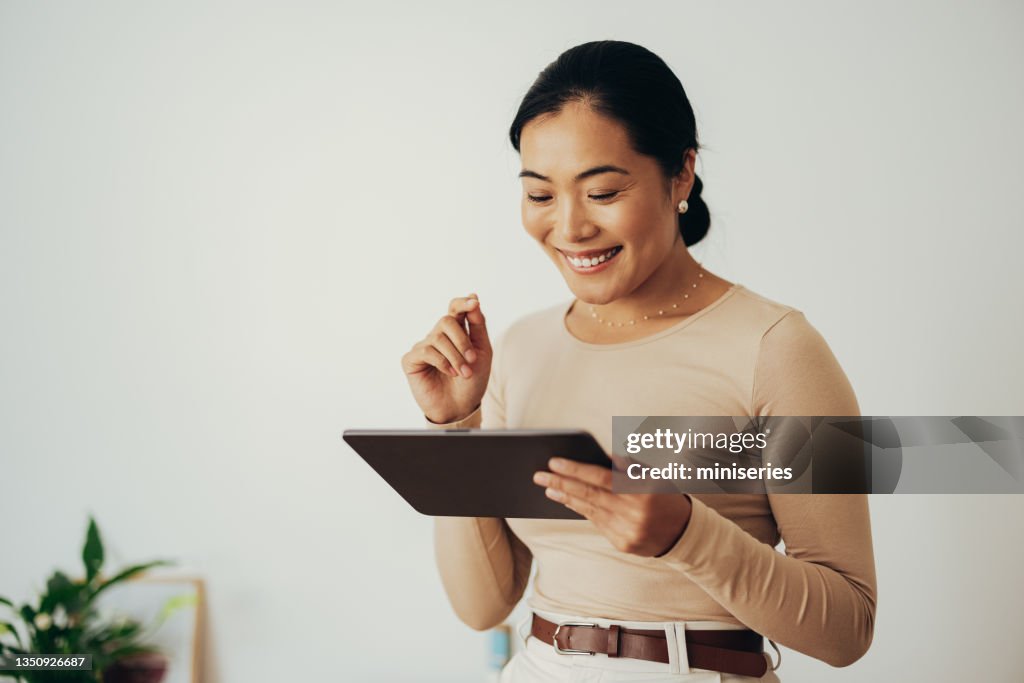Glückliche Geschäftsfrau mit digitalem Tablet zu Hause