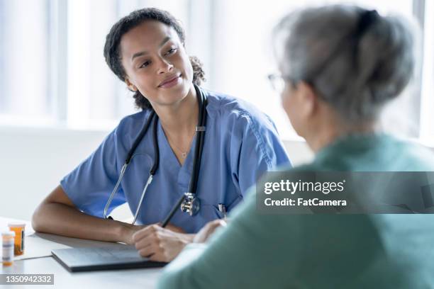 nurse taking notes - clinic canada diversity imagens e fotografias de stock