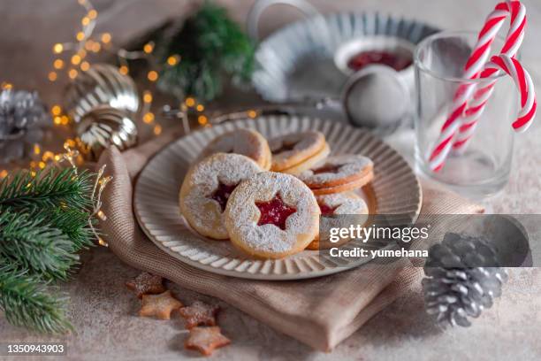 linzer christmas cookies filled with raspberry jam on concrete background - winter jam stock pictures, royalty-free photos & images