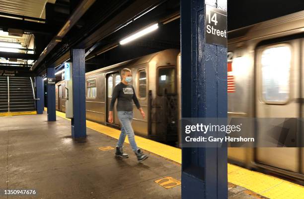 Person walks to board a red line train at the 14th Street subway station under 7th Avenue on November 2 in New York City.