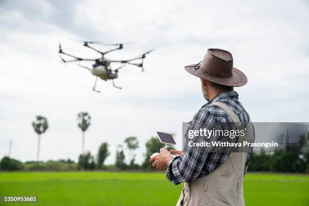 farmer spraying his crops using a drone - farmer drone stock pictures, royalty-free photos & images