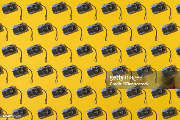 35mm analog photo cameras pattern on yellow background. vintage, retro and analog photography concept. - abundance stock pictures, royalty-free photos & images