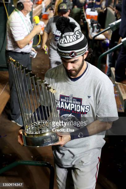 Dansby Swanson of the Atlanta Braves celebrates with the Commissioner's Trophy after the team's 7-0 victory against the Houston Astros in Game Six to...
