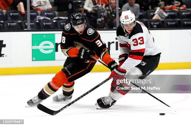 Ryan Graves of the New Jersey Devils defends against Derek Grant of the Anaheim Ducks as he controls the puck during the third period of a game at...