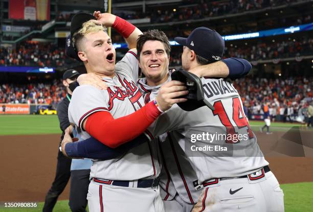 Joc Pederson, Luke Jackson, and Adam Duvall of the Atlanta Braves celebrate on the field after defeating the Houston Astros 7-0 in Game Six of the...