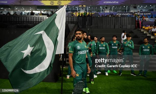 Pakistan captain Babar Azam stands with a Pakistan flag as he waits to lead on his team ahead of the ICC Men's T20 World Cup match between Pakistan...