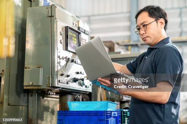 the japanese officer holding clipboard for check the capacity for check his performance at manufacturing factory . manufacturing and factory concepts - protocolo fotografías e imágenes de stock