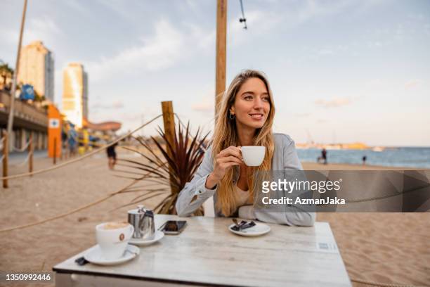 young caucasian drinking coffee in a beach bar - barcelona coast stock pictures, royalty-free photos & images