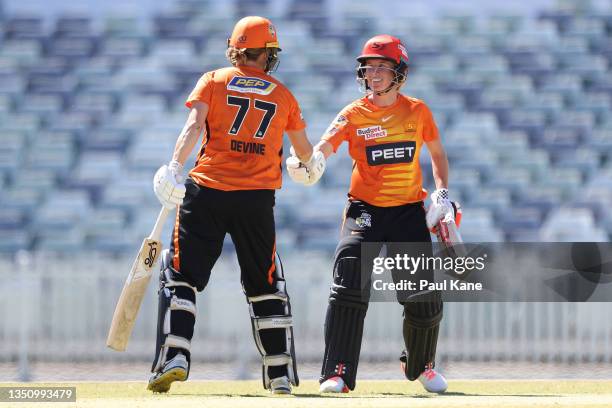 Sophie Devine and Beth Mooney of the Scorchers celebrate their 100 runs partnership during the Women's Big Bash League match between the Melbourne...