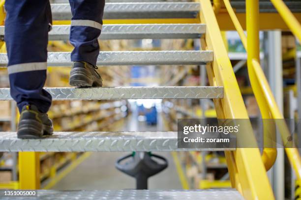 trabajador del almacén que sube las escaleras del almacén - metallic shoe fotografías e imágenes de stock