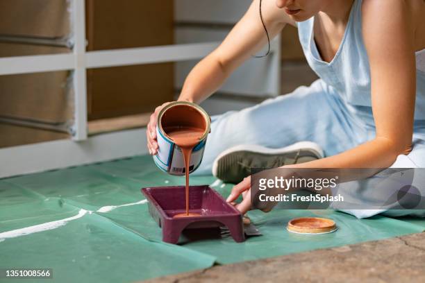 mujer irreconocible vertiendo pintura en una bandeja - paint tray fotografías e imágenes de stock