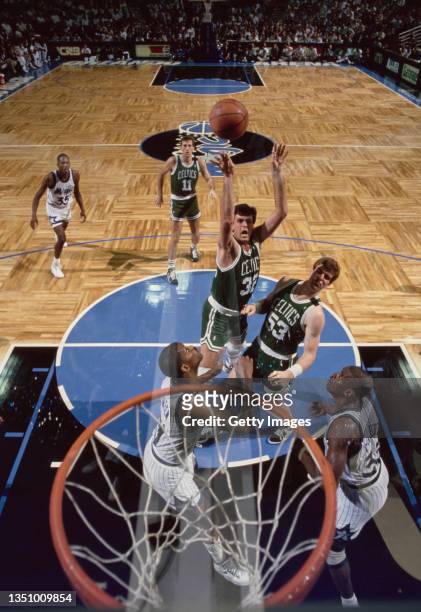 Kevin McHale, Power Forward for the Boston Celtics attempts to shoot for the hoop over team mate Joe Kleine as Sidney Green and Terry Catledge of the...