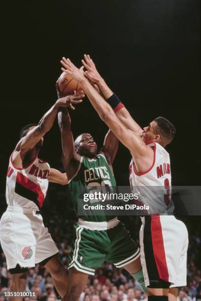 Sherman Douglas, Point Guard for the Boston Celtics challenges for the basketball as Tracy Murray of the Portland Trail Blazers attempts to block...