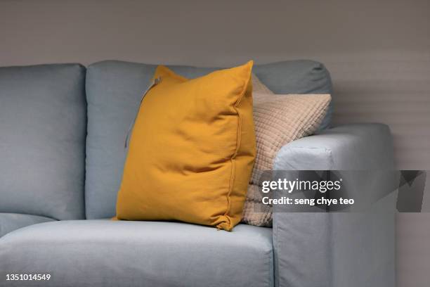 portion close-up of empty fabric sofa with 2 colourful cushion - cushion stockfoto's en -beelden