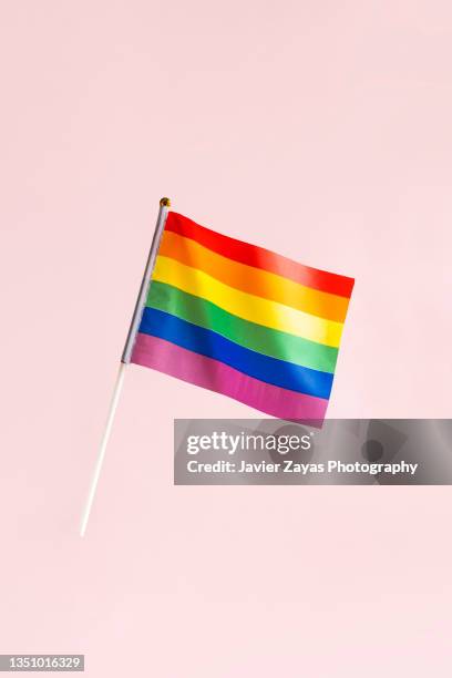rainbow flag waving on pink background - stolz freisteller stock-fotos und bilder