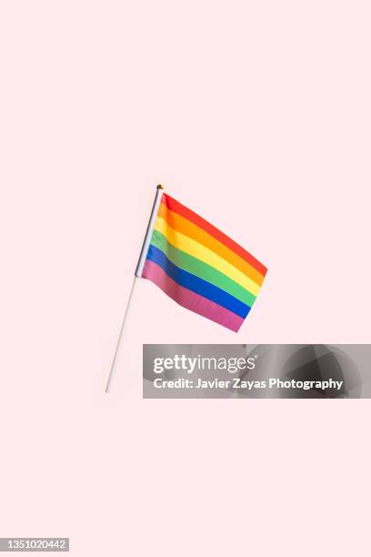 rainbow flag waving on pink background - gay pride flag stock pictures, royalty-free photos & images