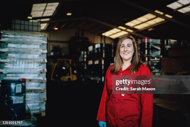 portrait of manager in red overalls - femalefocuscollection stock-fotos und bilder