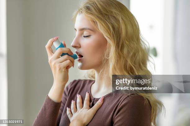 mujer con inhalador para el asma - asmático fotografías e imágenes de stock