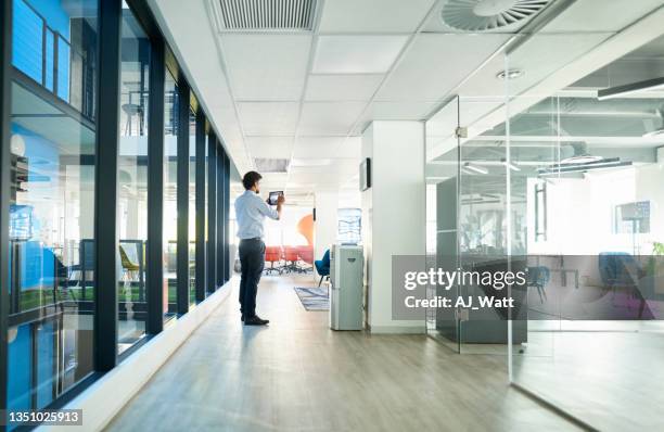 real estate agent taking pictures of office space using digital tablet - real estate office stockfoto's en -beelden