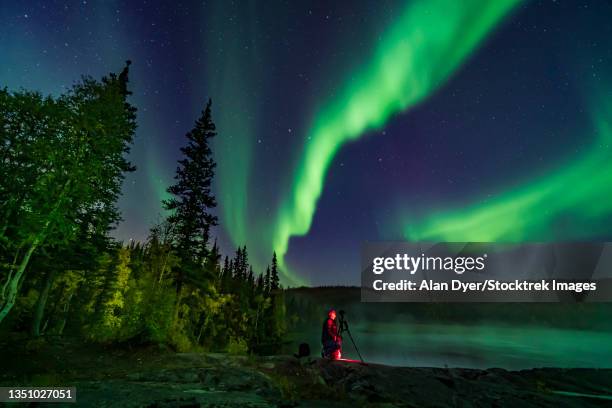 photographer shooting the northern lights on the cameron river in canada. - yellowknife stock pictures, royalty-free photos & images