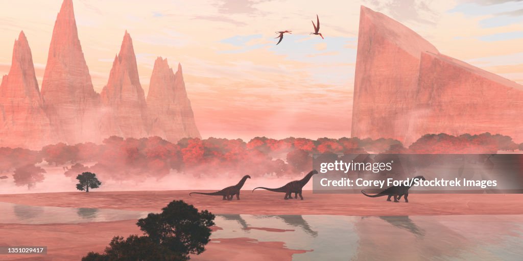 Alamosaurus dinosaurs walking along a riverbank, with pterosaurs flying overhead.