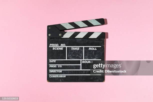 old wooden movie clapperboard with hard shadow on pink background. concept of film industry, cinema, entertainment, and hollywood. - clap de cinéma photos et images de collection