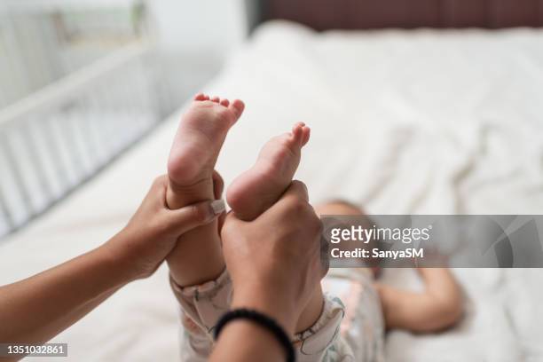 little baby receiving chiropractic or osteopathic foot massage - osteopath stock pictures, royalty-free photos & images