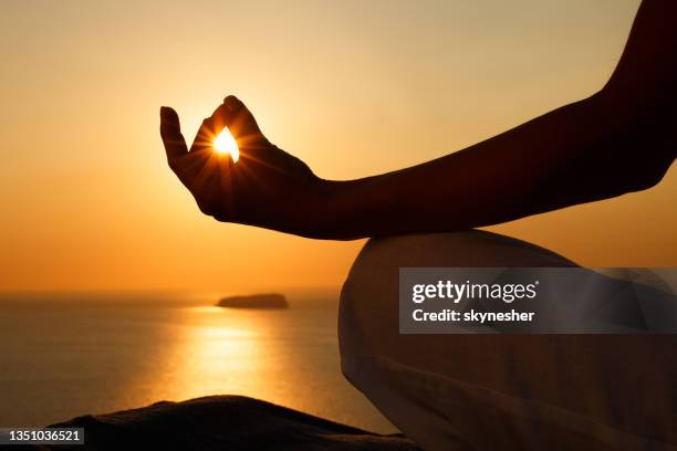 meditieren in lotusposition bei sonnenuntergang! - mediteren stock-fotos und bilder