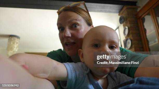 1 year old boy in his mother's arms taking selfies - 40 year old male face stockfoto's en -beelden