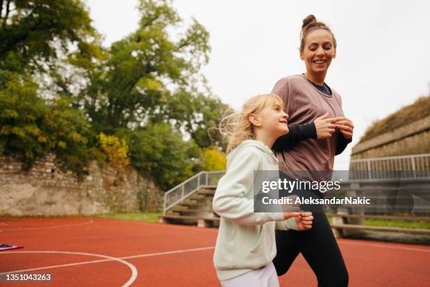 mother and daughter exercise together - atlete stockfoto's en -beelden