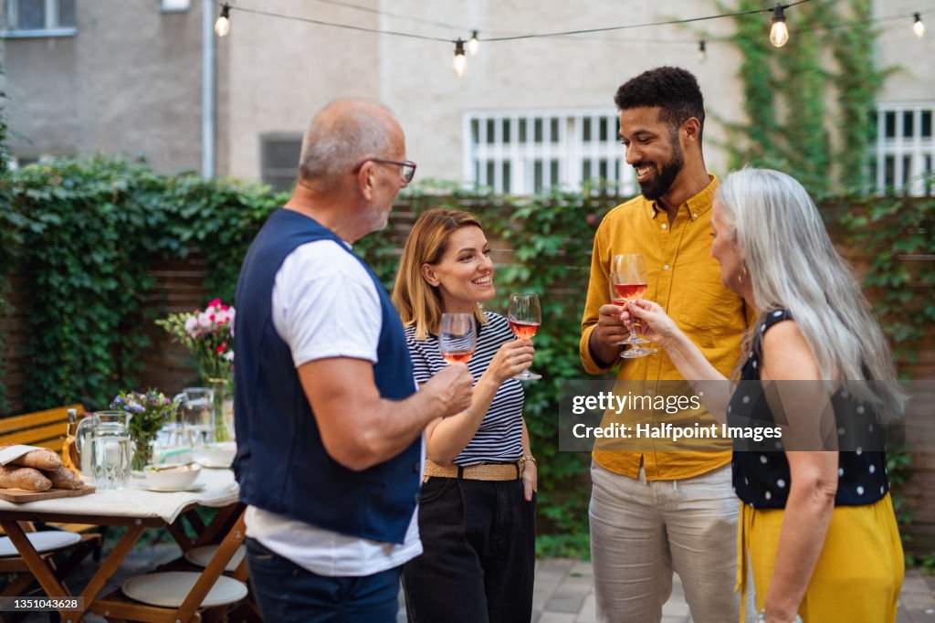 Happy multiracial family celebrating birthday outdoors in garden.