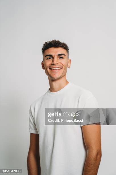 portrait of a young adult man against a white background - white t shirt studio stock pictures, royalty-free photos & images