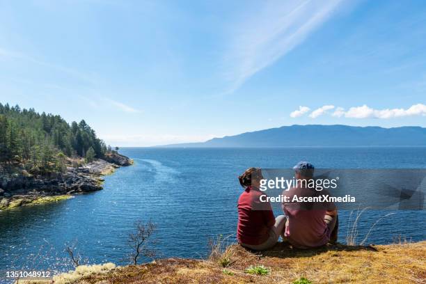 hiking couple relax at viewpoint, on mountain ridge - canada wine stock pictures, royalty-free photos & images
