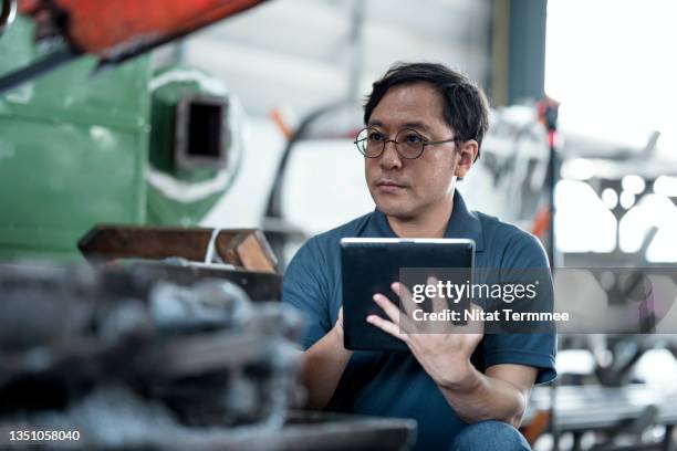 analyzing machine failures in a production process. shot of senior maintenance engineer using machine monitoring software to check status, workload, downtime, and utilization to improve productivity in production process. - aprendizaje automático fotografías e imágenes de stock