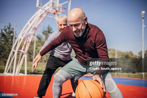 ältere männer spielen ball - basketball verteidiger stock-fotos und bilder