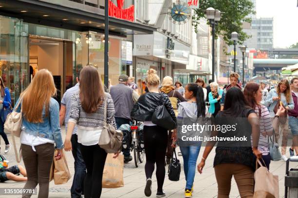 crowd of people and young women with shopping bags in essen - pedestrian zone 個照片及圖片檔