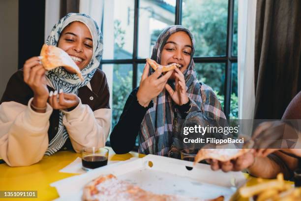 three friends are eating pizza together - moroccan culture stock pictures, royalty-free photos & images