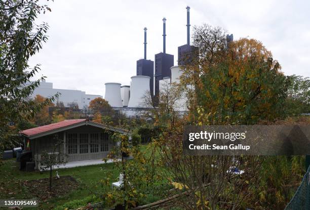 The Heizkraftwerk Lichterfelde natural gas-fired power and heating plant stands behind an allotment colony of garden houses on November 03, 2021 in...