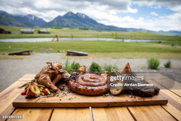 a huge platter of fresh barbeque with scenic mountains in the distance - portion stock pictures, royalty-free photos & images