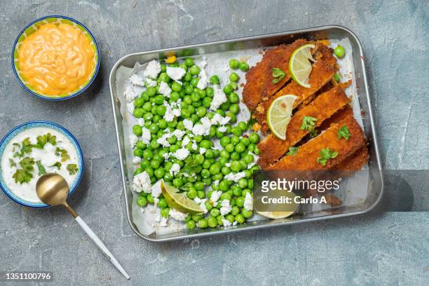 chicken schnitzel , green peas and feta - schnitzel stock-fotos und bilder
