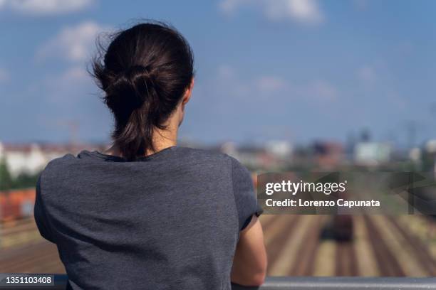 man leaning on railing on bridge - long hair back stock pictures, royalty-free photos & images