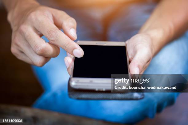 close up of a woman hand using a smart phone on a desk at home - protective sportswear ストックフォトと�画像