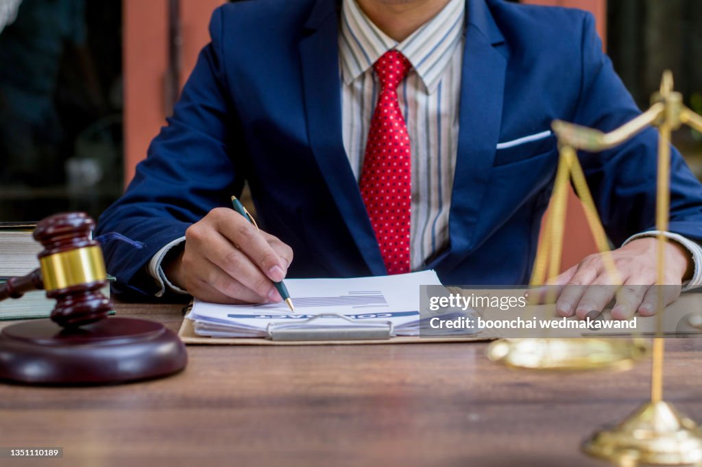 Close up lawyer businessman working or reading lawbook in office workplace for consultant lawyer concept.
