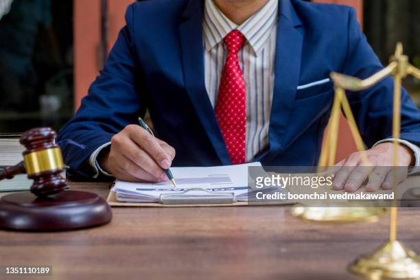close up lawyer businessman working or reading lawbook in office workplace for consultant lawyer concept. - legal occupation stockfoto's en -beelden