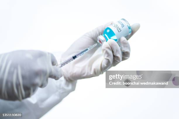 doctor, nurse, scientist, researcher hand in blue gloves holding flu, measles, coronavirus, covid-19 vaccine disease preparing for human clinical trials vaccination shot, medicine and drug concept. - measles hand stock pictures, royalty-free photos & images
