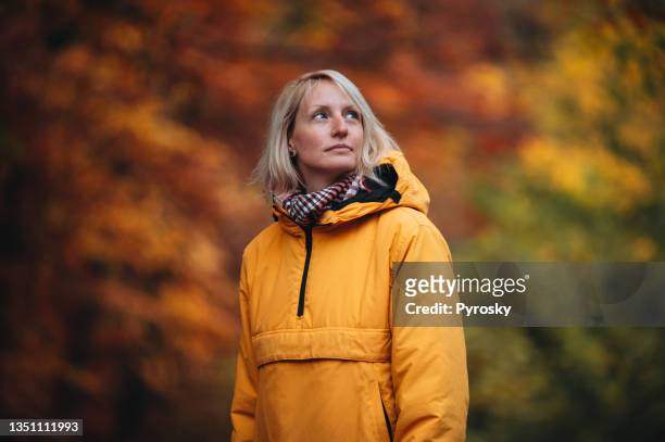 woman in the nature in autumn - orange jacket stock pictures, royalty-free photos & images