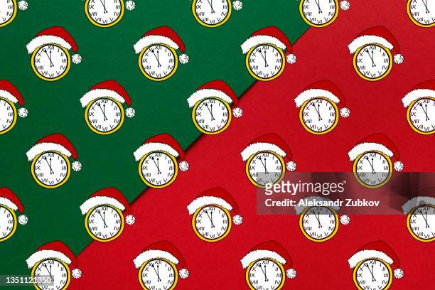the dial of the retro watch is set to twelve o'clock on new year's eve. christmas clock in a santa claus hat or cap, on a red background. the minute hands are set five minutes before the new year. seamless pattern. holiday wrapping paper template. - christmas countdown stock pictures, royalty-free photos & images