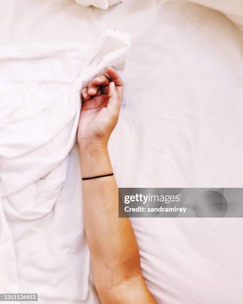 overhead view of a woman's arm in bed - arm pit stockfoto's en -beelden