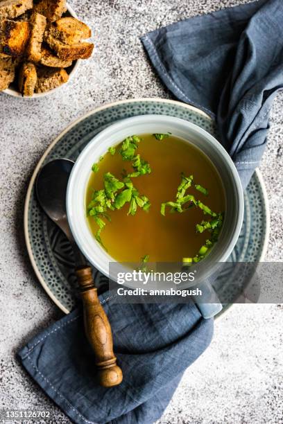 bowl of healthy chicken broth with croutons and parsley - broth stock pictures, royalty-free photos & images