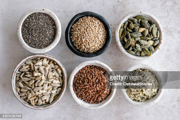 bowls of chia, sesame, pumpkin, sunflower, flax sesame and hemp seeds on a table - hemp seed 個照片及圖片檔